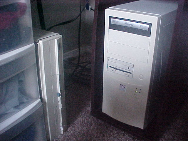 PC tower in desk cubby, alongside a PS/2 Model 55SX stood vertically
